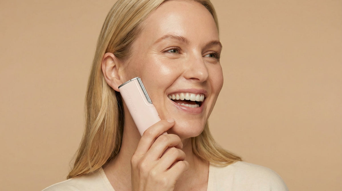 Woman gliding the GLEAUX ONE+ sonic dermaplaning pen along her cheek